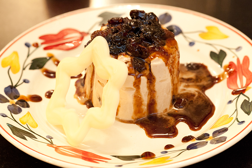 Witte pudding met cranberry's en rozijnen op een bord met een sterretje van witte chocolade ter decoratie 